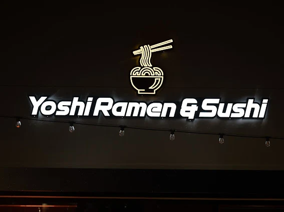Yoshi Ramen & Sushi neon storefront sign at night